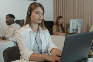Employés multiraciaux du centre d'appels concentrés sur la fourniture d'un support client avec des ordinateurs portables.