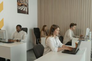 Scène de bureau avec des employés du centre d'appels au travail, mettant l'accent sur le travail d'équipe et la productivité.