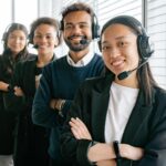 Un groupe diversifié d'agents de centre d'appels souriants dans un environnement de bureau.
