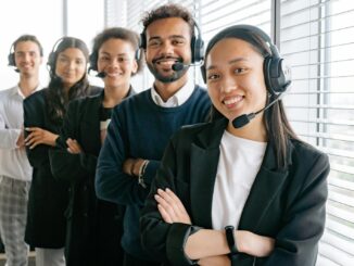 Un groupe diversifié d'agents de centre d'appels souriants dans un environnement de bureau.