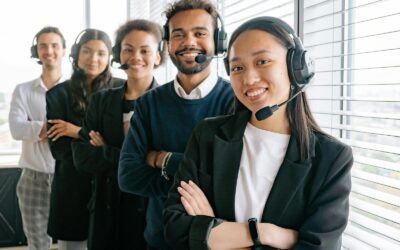 Un groupe diversifié d'agents de centre d'appels souriants dans un environnement de bureau.