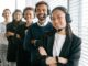 Un groupe diversifié d'agents de centre d'appels souriants dans un environnement de bureau.